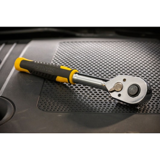 STANLEY STMT82665-0 ratelsleutel met geel-zwarte handgreep op geperforeerd oppervlak.