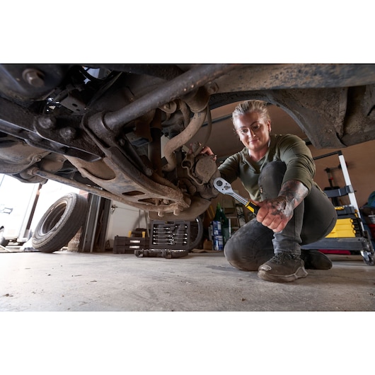Foto van STANLEY STMT82665-0 1272-ToothRatchet gebruikt onder een voertuig in een garage.