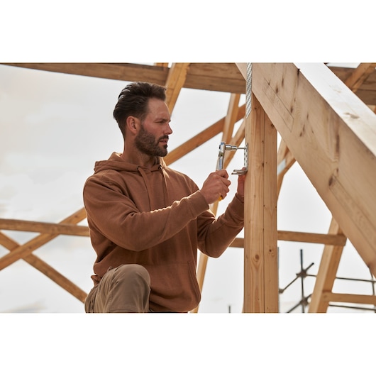 STANLEY STMT82665-0 ratelgereedschap toegepast op houten constructie buiten.