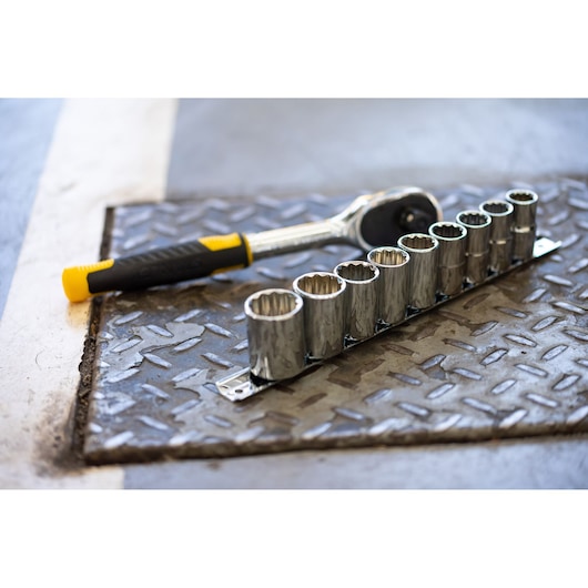 STANLEY STMT82666-0 ratelsleutel en negen-delige doppenset op metalen vloer, schuine hoek.