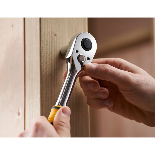 STANLEY STMT82671-0 ratelsleutel wordt met de hand afgesteld bij houten oppervlak, close-upfoto.