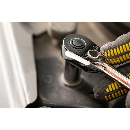 STANLEY STMT82672-0 ratelsleutel in gebruik, close-up met handschoen en socket bevestiging.