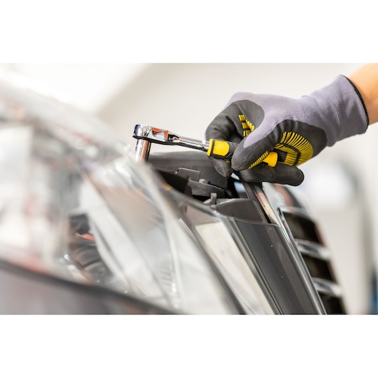 STANLEY STMT82672-0 ratelset gebruikt op autokoplamp, close-up, met grip en gele details.