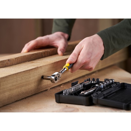 STANLEY STMT82672-0 ratelset gebruikt op hout, close-up hoek, open doos met doppen en bits zichtbaar.