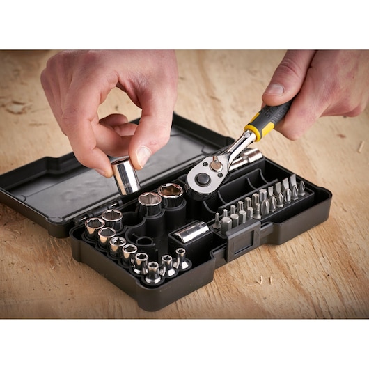 STANLEY STMT82672-0 dop- en bitset met ratel, zwarte koffer, close-up op houten oppervlak.