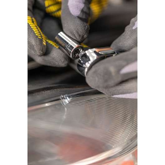 STANLEY STMT82828-1 dopsleutel gereedschap vastgehouden door een handschoen, close-up met reflecterend oppervlak.