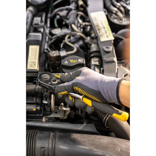 STANLEY STMT82830-1 ratelsleutel vastgehouden door gehandschoende hand, autoreparatie.