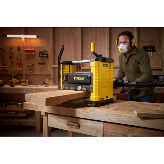 STANLEY STP18-B2 raboteuse de table en utilisation sur une planche en bois, atelier, vue de face.