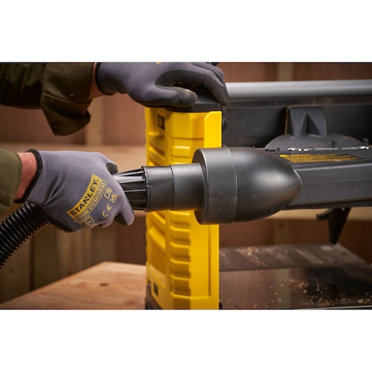 STANLEY STP18-B2 photographie montrant des mains gantées connectant un tuyau à un outil électrique jaune.