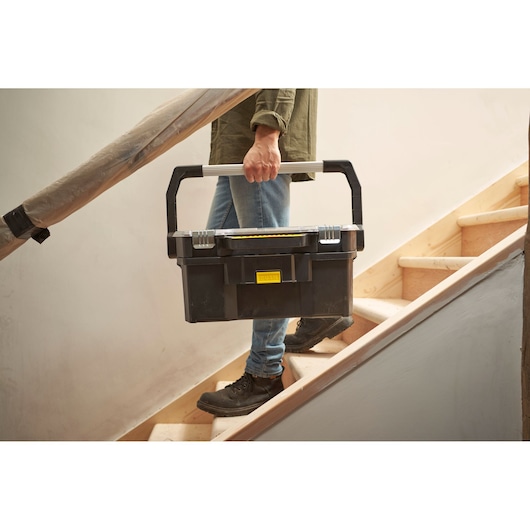 STANLEY STST1-70317 zwarte gereedschapskist met zilveren handgreep op trap, productfotografie.