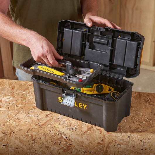 STANLEY STST1-75518-KR boîte à outils noire avec plateau, remplie d’outils, sur surface en bois.