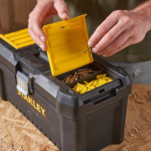 Caisse à outils STANLEY STST1-75518-KR avec couvercle de compartiment jaune ouvert, vis et chevilles, photo en gros plan.