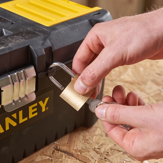 Photo de la boîte à outils STANLEY STST1-75518-KR avec cadenas en cours de déverrouillage, vue rapprochée.