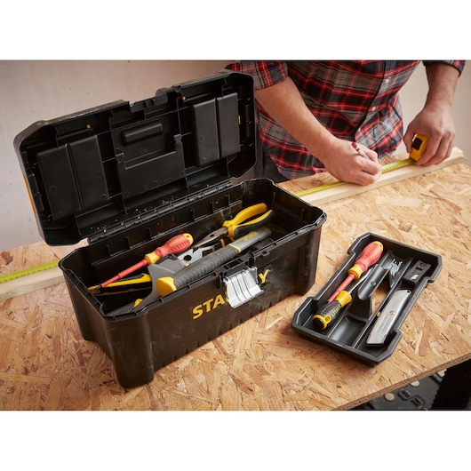 STANLEY STST1-75518-KR boîte à outils noire ouverte avec outils, plateau à côté sur l'établi.