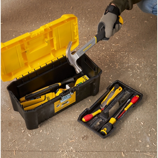 STANLEY STST75785-1 gereedschapskist open op werkvloer met diverse handgereedschappen en gele uitneembare lade.