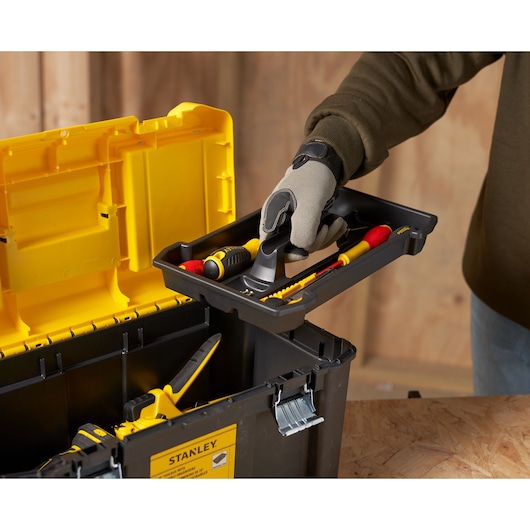 STANLEY STST75787-1 boîte à outils avec couvercle jaune, plateau amovible, main tenant le plateau avec outils, vue latérale