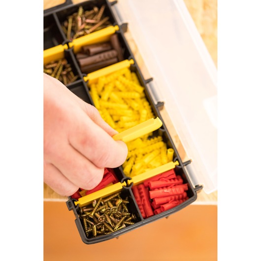 Organiseur STANLEY STST81679-1 avec vis et chevilles assorties, main ouvrant un compartiment, vue de dessus.