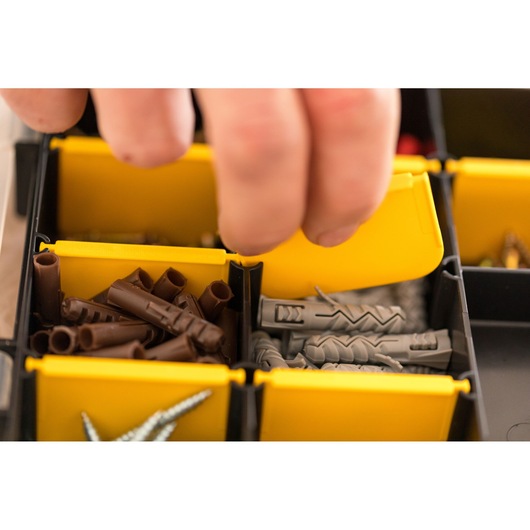STANLEY STST81680-1 boîte organisatrice avec compartiments jaunes, contenant vis et chevilles, vue rapprochée.