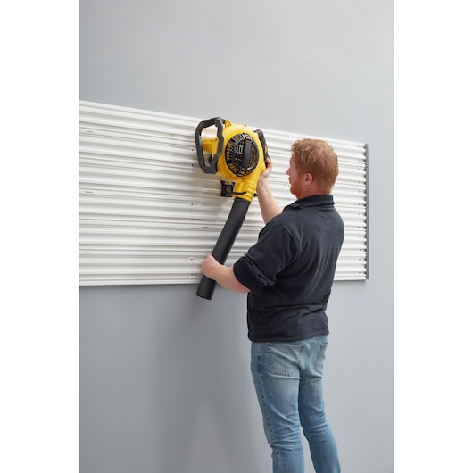 STANLEY STST82609-1 photographie de panneau mural utilisé pour accrocher un souffleur de feuilles jaune.