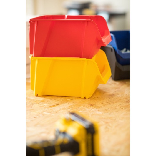 STANLEY STST82739-1 bacs de rangement empilables rouge et jaune sur surface bois, photographie latérale.
