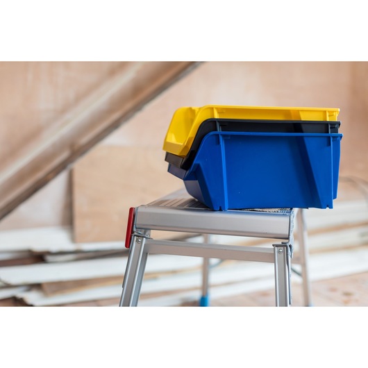 STANLEY STST82743-1 bacs empilables jaunes et bleus sur escabeau métallique, vue latérale.