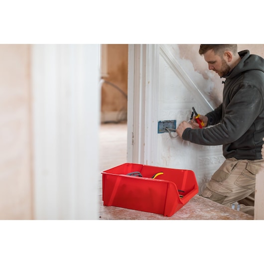 STANLEY STST82745-1 bac de rangement rouge pour outils et câbles utilisé lors de travaux électriques, vue latérale.