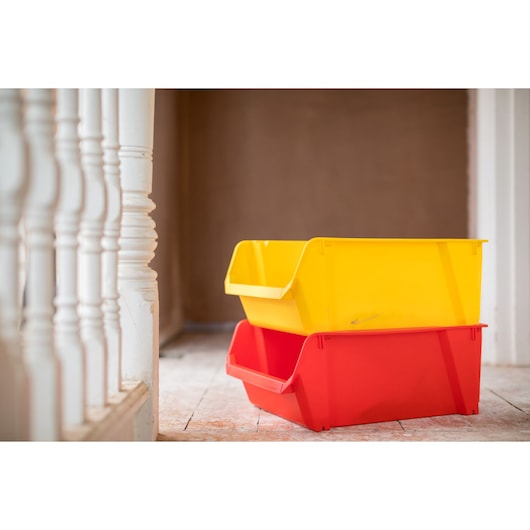 STANLEY STST82745-1 bacs de rangement empilables jaune et rouge sur plancher en bois, photo de côté.