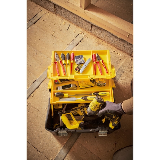 Stanley STST83397-1 gereedschapskist met diverse handgereedschap, gele lade en elektrisch gereedschap, bovenaanzicht.