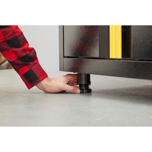 STANLEY STST97595-1 kast, verstelbare poot close-up op betonnen vloer, hand draait knop.