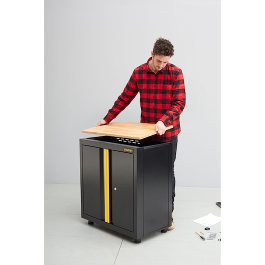 STANLEY STST97595-1 opbergkast zwart met gele streep, getoond tijdens montage met houten blad.