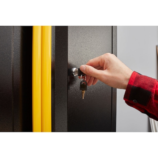 Foto van STANLEY STST97598-1 kast met gele handgrepen die wordt vergrendeld met een sleutel, close-up.