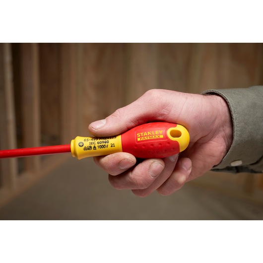 Foto van STANLEY XTHT0-62692 geïsoleerde schroevendraaier met rood-gele handgreep in hand.